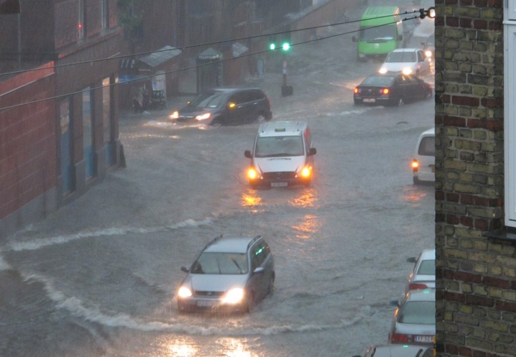 Überflutete Straße in der Autos durchs Wasser fahren
